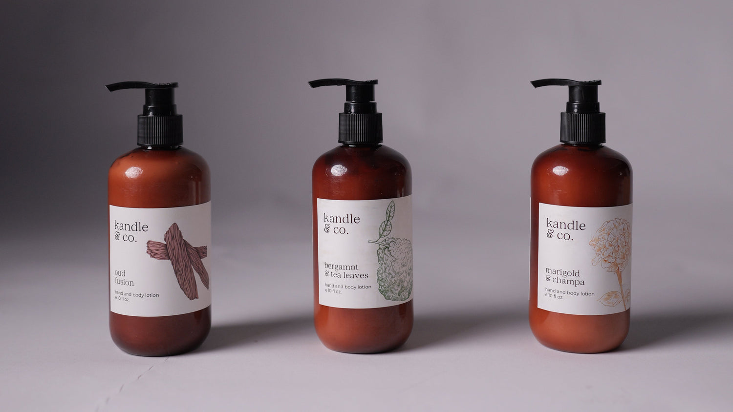 Three bottles of body care products with labels on a gray background